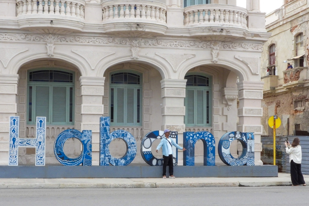 A man poses for a photo in front of a sculpture spelling out the name Havana on the Malecon waterfront in Havana on January 1, 2026. — AFP pic