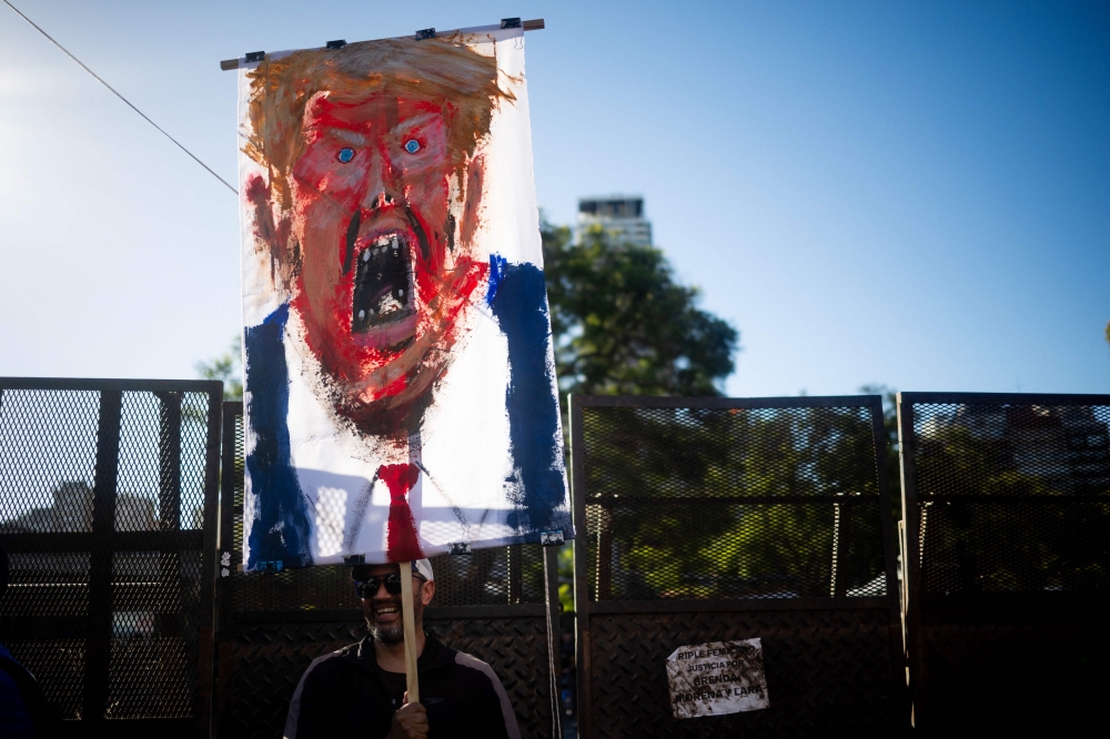 A man holds a painting of US President Donald Trump during a protest against the US intervention in Venezuela in Buenos Aires on January 5, 2026. — AFP pic