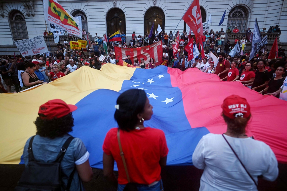 People display a giant Venezuelan flags as they take part in a demonstration in support of Venezuela’s President Nicolas Maduro at the Cinelandia square in Rio de Janeiro, Brazil, on January 5, 2026, after US forces captured Venezuelan leader Nicolas Maduro. — AFP pic