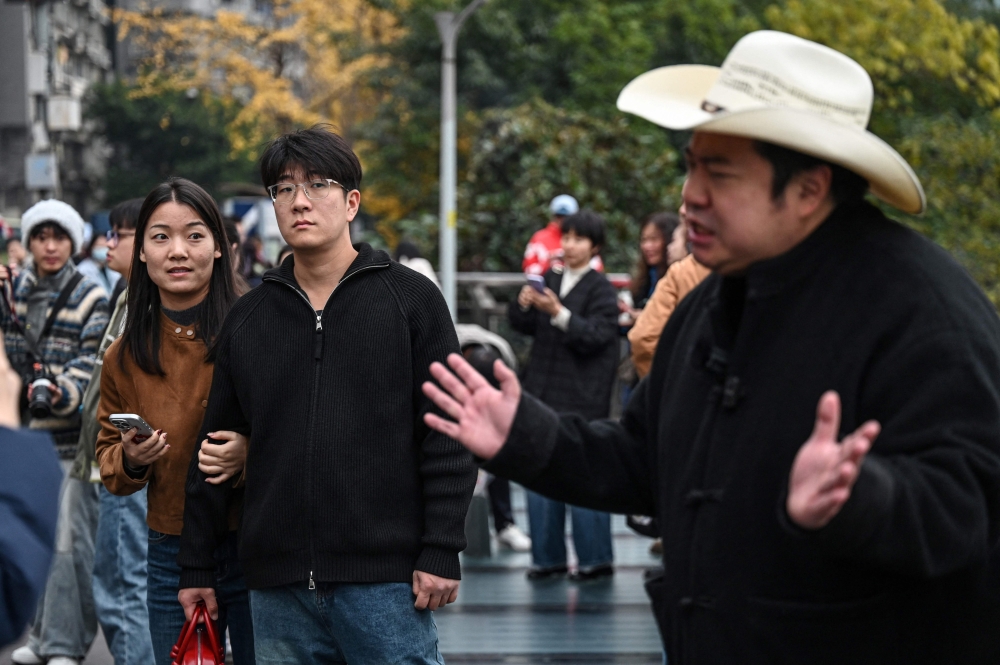 People look on in amusement as China’s Trump impersonator Ryan Chen records a video in Chongqing, December 15, 2025. — AFP pic