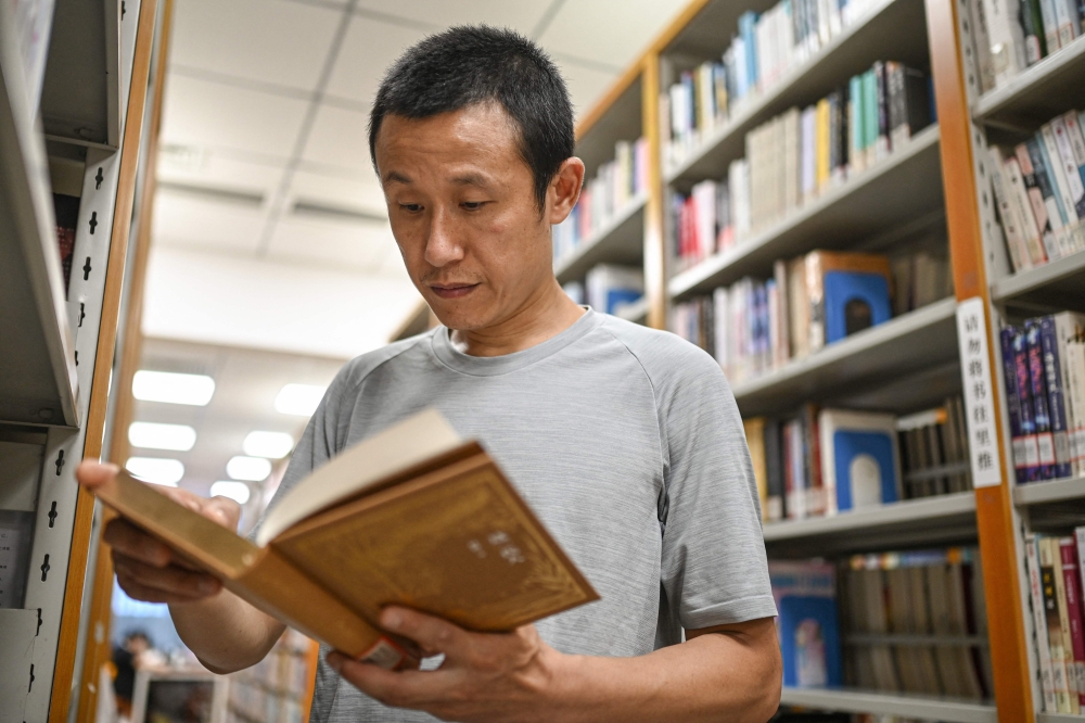This photo taken on August 18, 2025 shows author Hu Anyan reading a book at a public library in Chengdu, in southwestern China's Sichuan province. — AFP pic