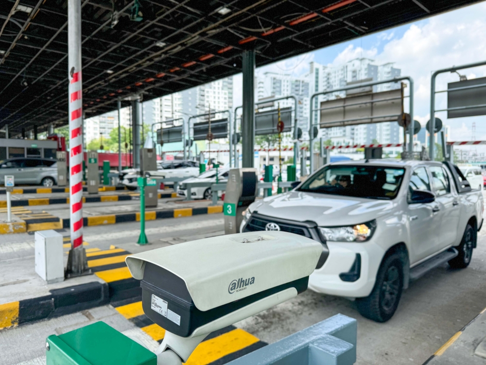 A vehicle passes through a toll plaza equipped with ANPR technology, which allows registered motorists to use any lane without stopping during the pilot phase. — PLUS Malaysia Berhad pic