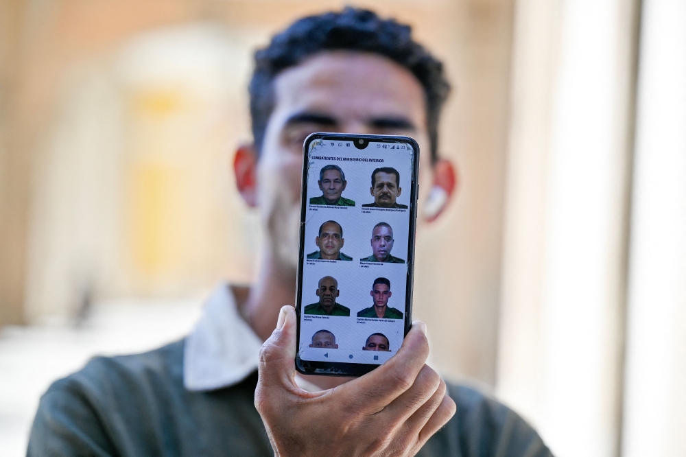 A man in Havana shows the official website of the Cuban government cubadebate.cu on his mobile phone, where images of some of the 32 Cuban officers and soldiers killed during the US military intervention in Venezuela are being displayed on January 6, 2026. — AFP pic 