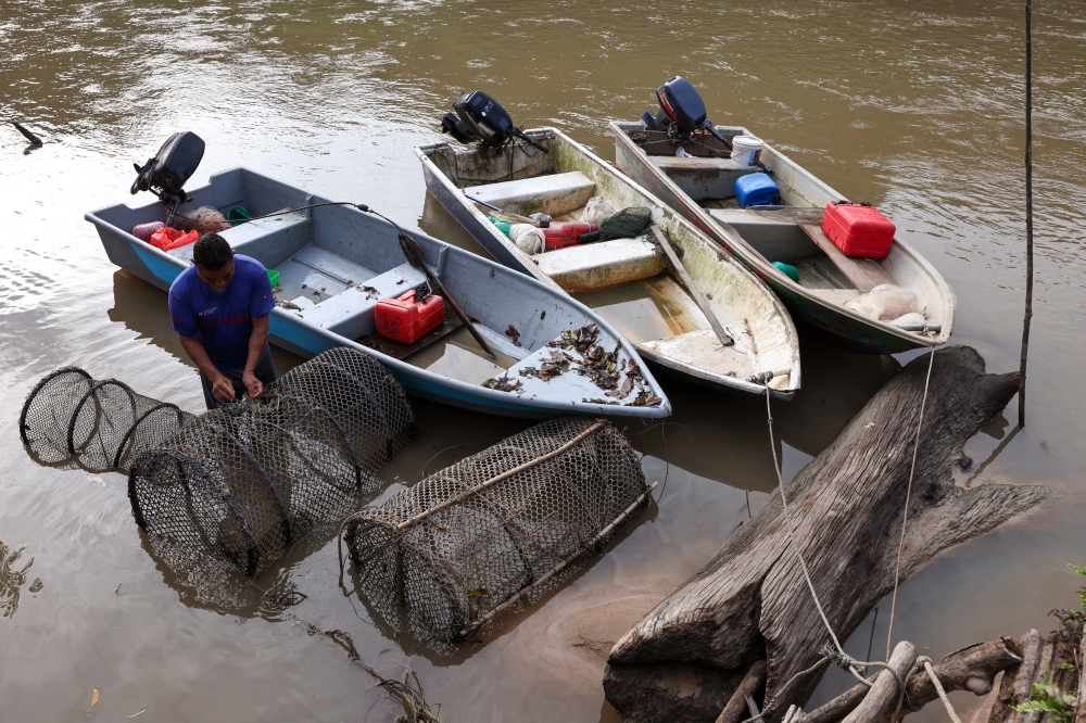 Fishing boats and traps lie idle at a village jetty as fishermen struggle with falling incomes, higher fuel costs and rivers that have yet to recover. — Bernama pic
