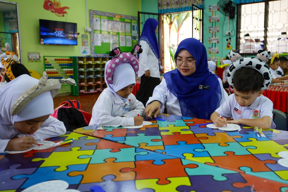 Pre-school student management assistant Najwa Atiqah Ibrahim assists students on the first day of the 2026 school session at Sekolah Kebangsaan Gong Tok Nasek, Kuala Terengganu January 11, 2026. — Bernama pic