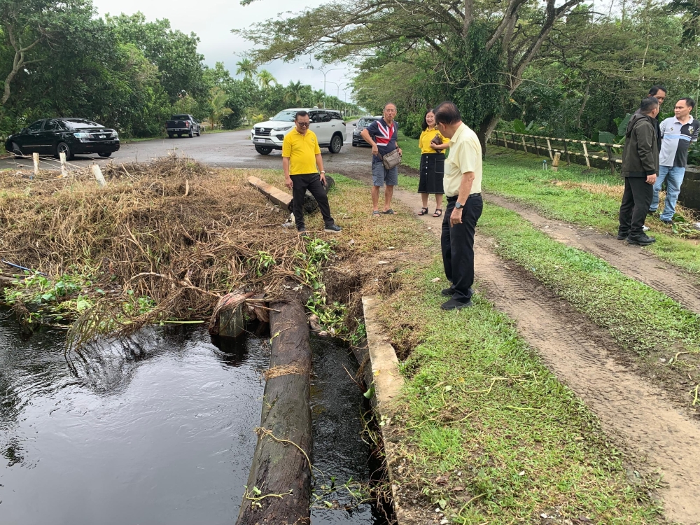 Sarawak Transport Minister Datuk Seri Lee Kim Shin (centre) inspects one of the drains in Senadin during his inspection on flood situation in the area on Sunday morning. — The Borneo Post
