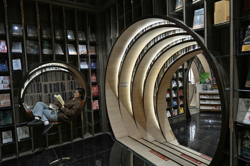 This picture taken on December 19, 2025 shows a woman reading a book at a bookstore in Beijing. — AFP pic