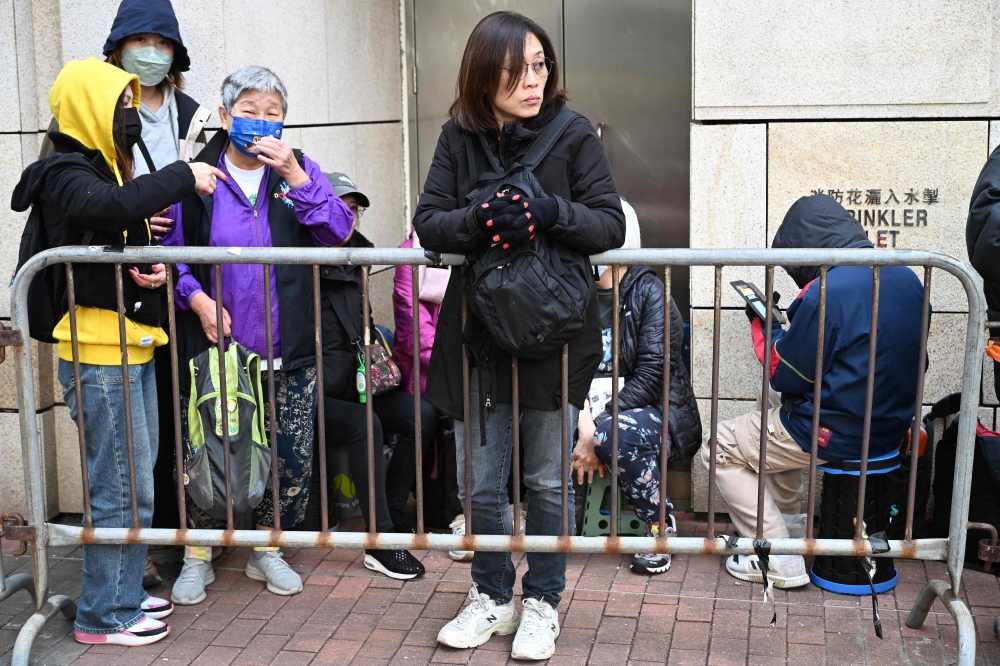 People queue outside the West Kowloon Magistrates' court in Hong Kong on January 12, 2026, for the sentencing arguments of convicted pro-democracy media tycoon Jimmy Lai. — AFP pic