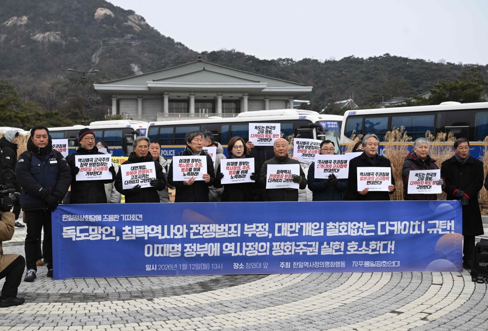 South Korean activists hold placards reading “Oppose military cooperation with Japan, which distorts history and violates sovereignty!” during an anti-Japan protest near the presidential Blue House in Seoul on January 12, 2026, ahead of the South Korea-Japan summit. — AFP pic