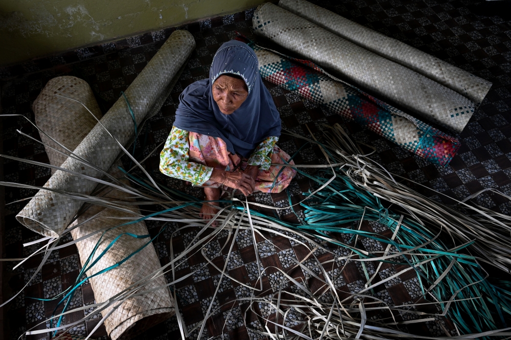 Eighty-eight-year-old Zainab Abu Bakar remains steadfast in preserving the art of weaving mengkuang mats. — Bernama pic