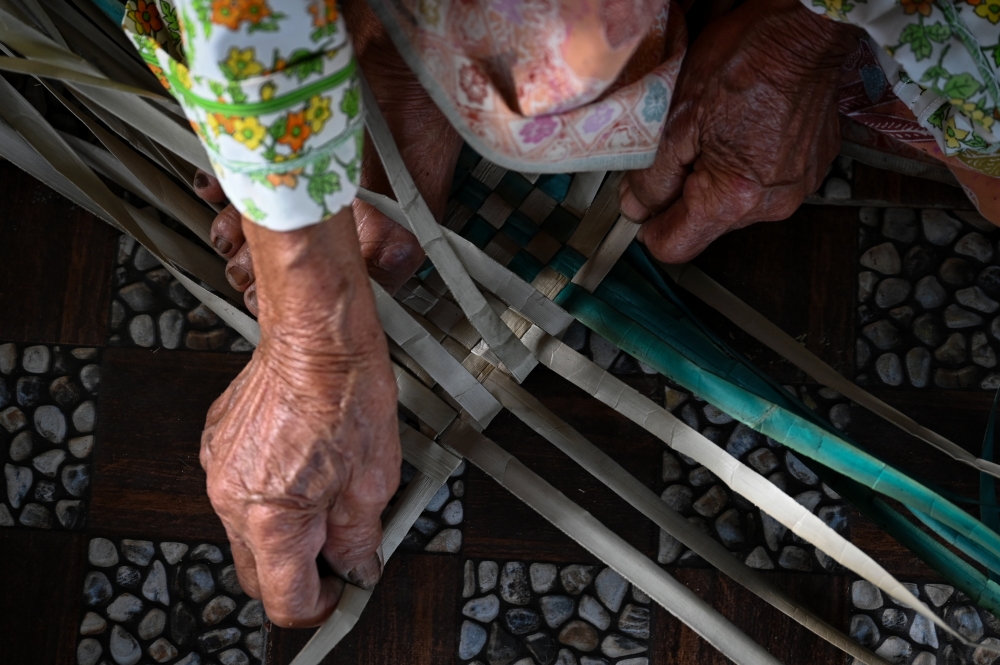 Zainab’s enduring touch transforms simple leaves into intricate mengkuang mats.— Bernama pic