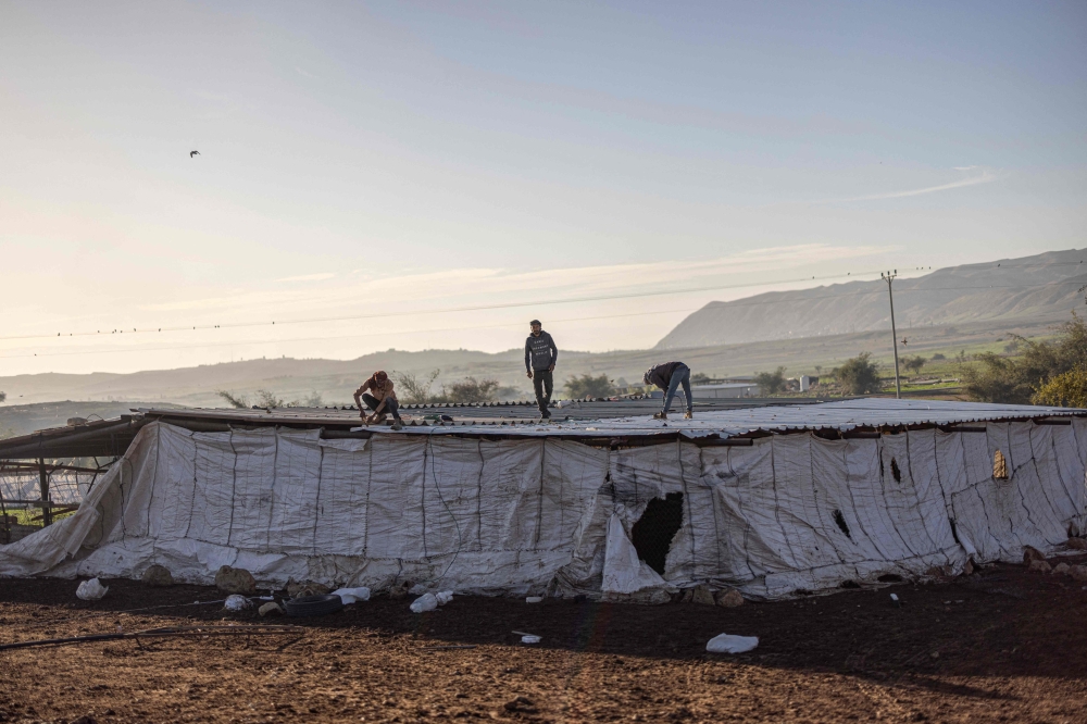 A Bedouin family dismantles a structure as they gather their belongings to leave their home after continues harassment from Israeli right-wing settlers in Ras Ein al-Auja. — AFP pic 