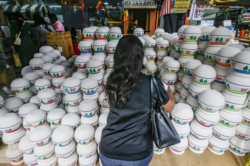 A woman looks at clay pots on sale in preparation for Pongal in Sentul January 13, 2024. While Thala Deepavali is customarily celebrated with the bride’s family, there is no hard‑and‑fast rule about which side the newlyweds should celebrate their Thala Pongal with. — Picture by Hari Anggara