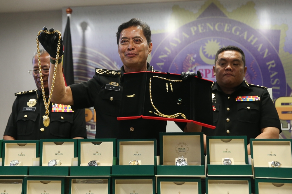 MACC Chief Commissioner Tan Sri Azam Baki holds up jewellery seized during an investigation linked to a former army chief at a press conference at the MACC headquarters in Putrajaya on January 15, 2026. — Picture by Yusof Isa