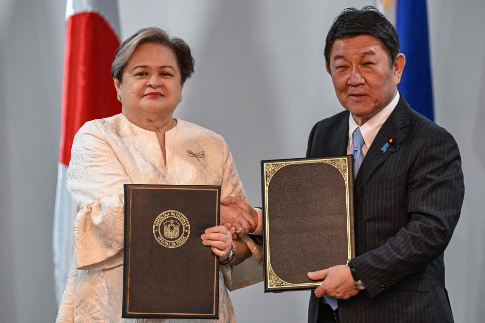 Philippines’ Foreign Minister Theresa Lazaro (L) and Japan’s Foreign Minister Toshimitsu Motegi exchange documents after signing agreements during a press conference in Pasay, Metro Manila on January 15, 2026. — AFP pic