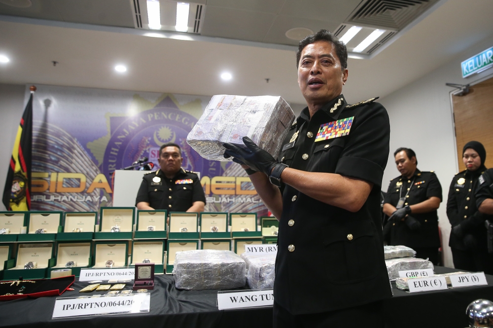 MACC Chief Commissioner Tan Sri Azam Baki exhibits cash seized during an investigation linked to a former army chief at a press conference at the MACC headquarters in Putrajaya on January 15, 2026. — Picture by Yusof Isa