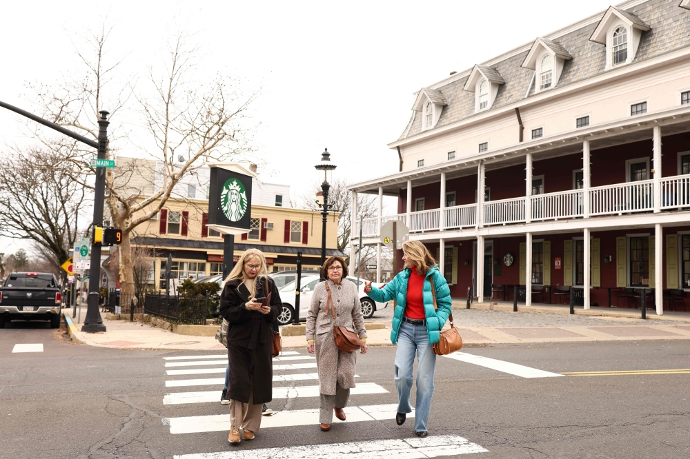 Women cross a street in Doylestown, Pennsylvania on January 14, 2025. Support for US President Donald Trump has waned since he took office last January, as opinion polls show a slump in the president's approval rating. — AFP pic