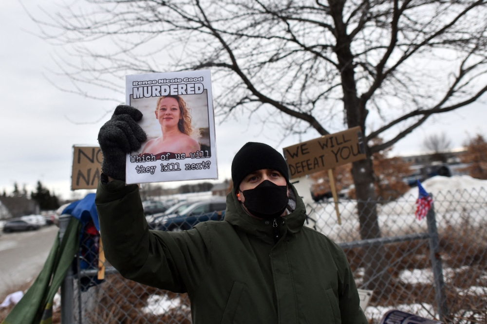 A demonstrator holds a sign with a photo of Renee Nicole Good, whose death at the hands of a US ICE agent, has reignited protests against Trump across the country. — AFP pic
