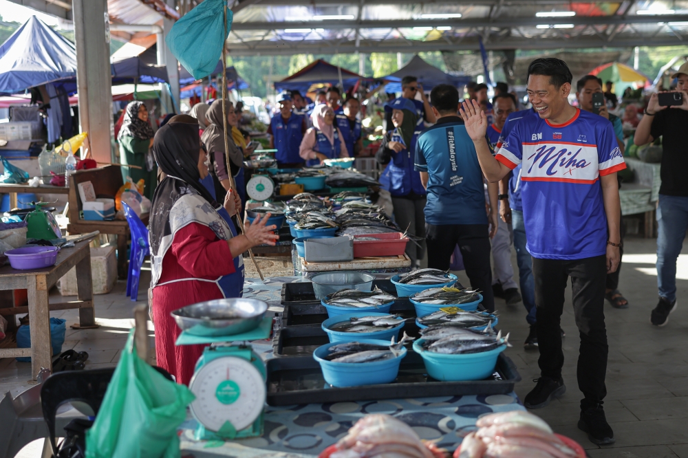 BN Lamag candidate Mohd Ismail ‘Miha’ Ayob greet traders during a walkabout ahead of the January 24, 2026 by-election. — Bernama pic