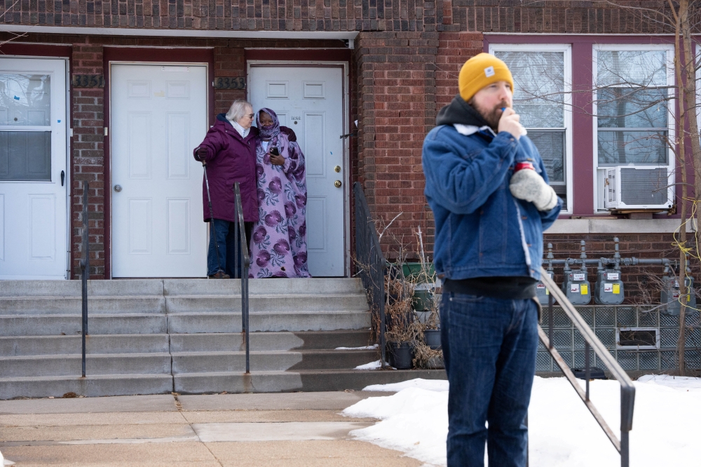 Two women embrace outside an apartment complex as an observer blows a whistle to alert neighbours of the presence of federal agents following an immigration raid, days after an agent fatally shot Renee Nicole Good, in Minneapolis, Minnesota January 13, 2026. — Reuters pic