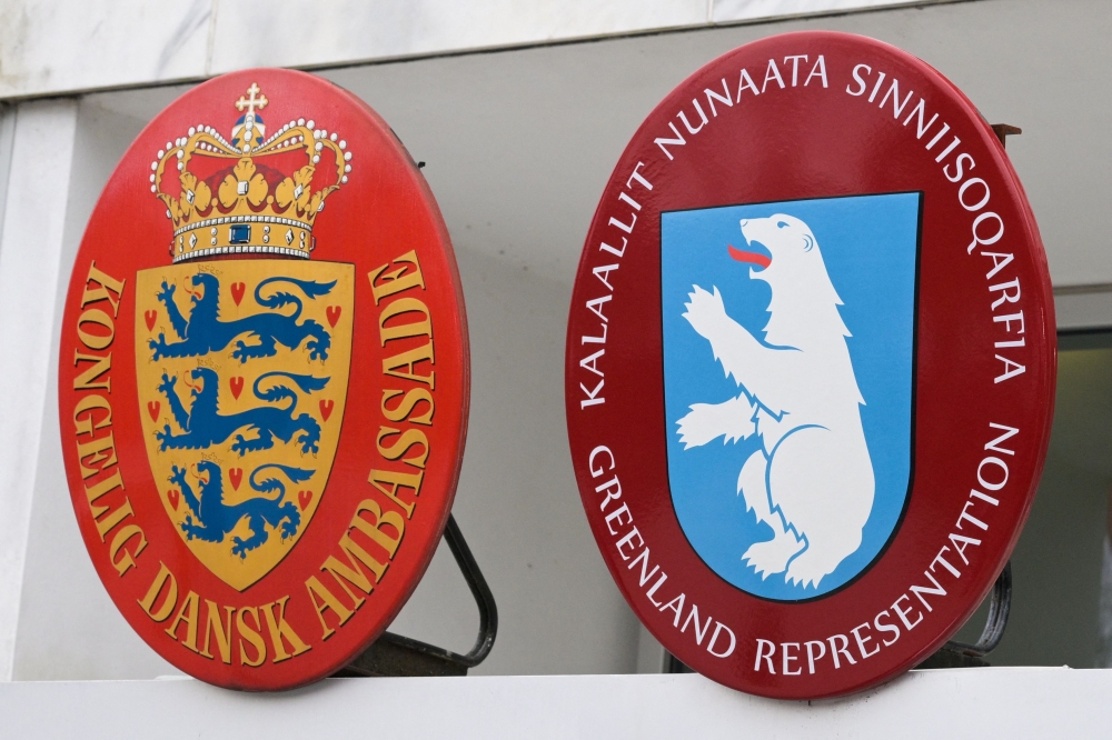 The Danish coat of arms (left) and Greenland's coat of arms (right) are seen at the Danish Embassy in Washington, DC. The Trump government insists that US control of Greenland would serve ‘national security’ and claims its Nato ally Denmark could not defend it against Russia or China. — AFP pic