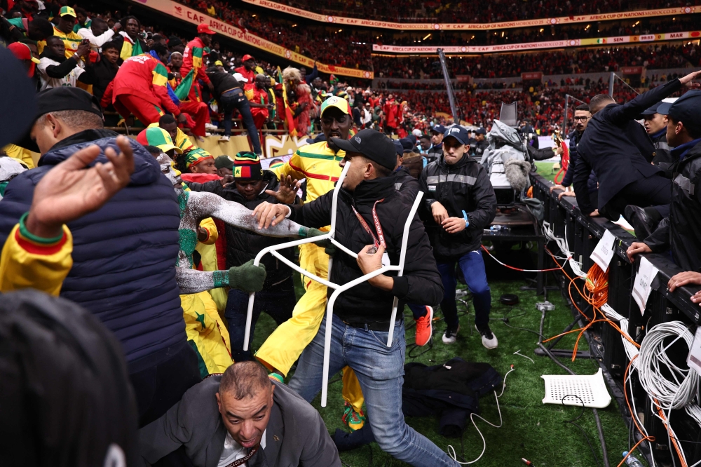 Fans scuffle with security personnel as they storm the field after a penalty decision against Senegal during the Africa Cup of Nations final football match between Senegal and Morocco at the Prince Moulay Abdellah Stadium in Rabat on January 18, 2026. — AFP pic