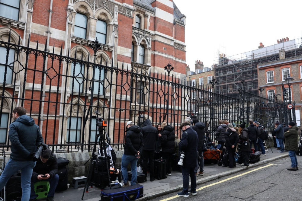 Members of the media wait outside the High Court in London yesterday. — AFP pic 