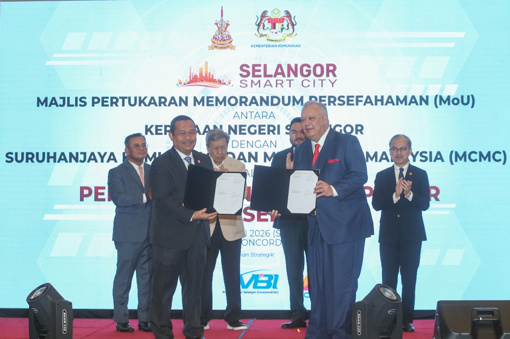 Selangor State Secretary Datuk Ahmad Fadzli Ahmad Tajuddin exchanges documents with Malaysian Communications and Multimedia Commission (MCMC) chairman Tan Sri Mohamad Salim Fateh Din during an MoU signing ceremony witnessed by Sultan of Selangor Sultan Sharafuddin Idris Shah Alhaj and Raja Muda Selangor Tengku Amir Shah Ibni Sultan Sharafuddin Idris Shah Alhaj at Concorde Hotel, Shah Alam, January 20, 2026. — Picture by Yusof Isa