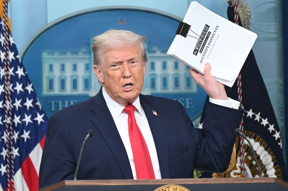 US President Donald Trump brandished a folder in front of reporters that he said listed 365 achievements since he was sworn in on January 20 last year. — AFP pic