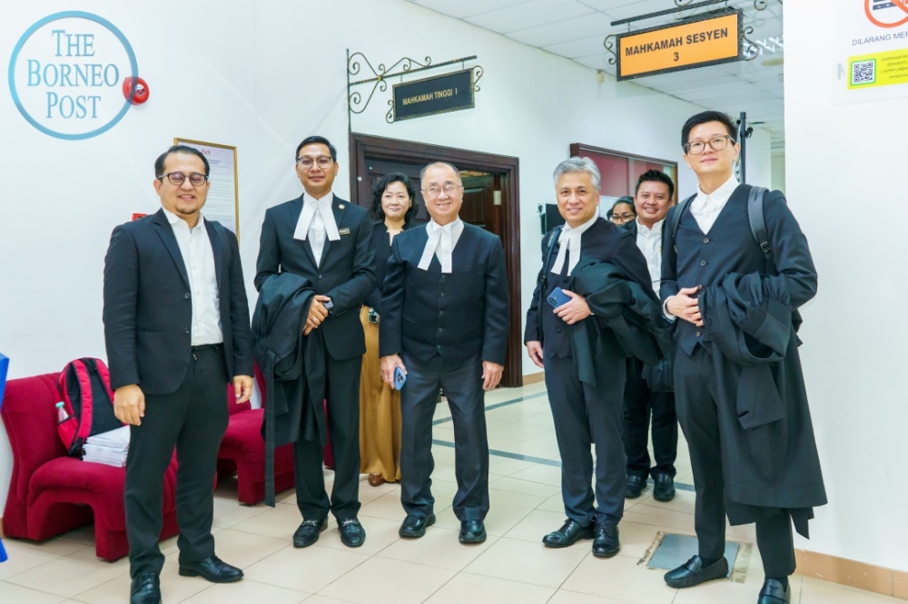 Fong (centre) with (from left) Ahmad Hanir, Adzrul, Khoo and Ngu after the court proceedings. — The Borneo Post pic