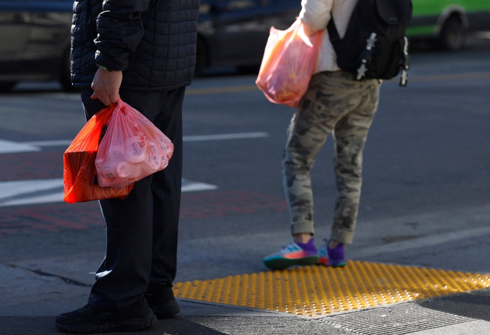 Pedestrians carry plastic shopping bags on January 16, 2026, in San Francisco, California. — AFP pic