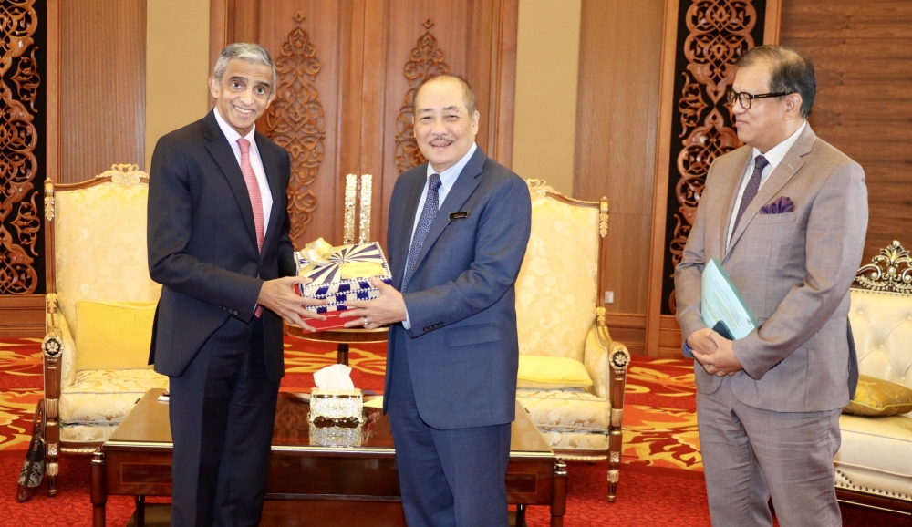 Hajiji presents a memento to the Singapore High Commissioner to Malaysia, HE Vanu Gopala Menon during the latter’s visit to his office at Menara Kinabalu on Thursday. — The Borneo Post pic
