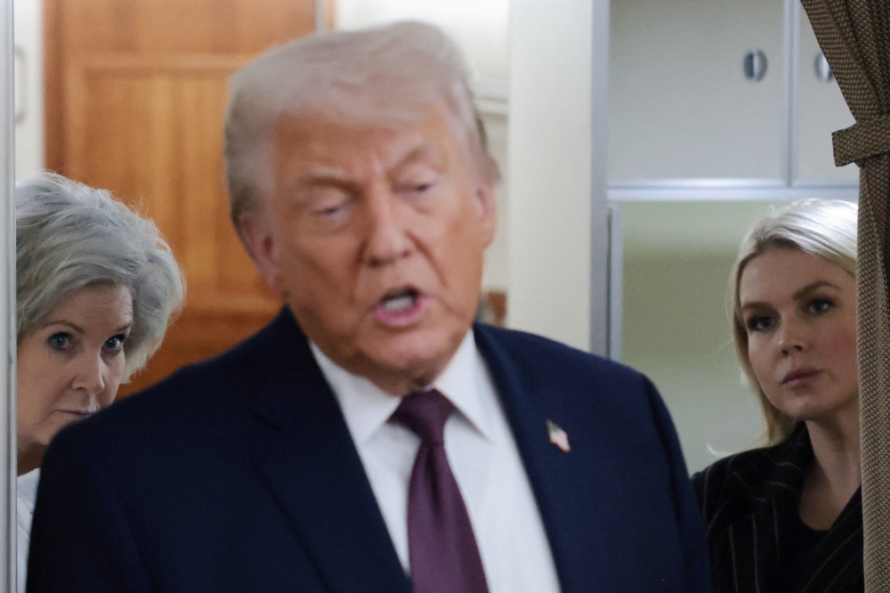 White House Chief of Staff Susie Wiles and White House Press Secretary Karoline Leavitt listen as US President Donald Trump speaks to reporters over the North Atlantic as he returns to Washington from the World Economic Forum (WEF) in Davos, Switzerland, aboard Air Force One, US, January 22, 2026. — Reuters pic