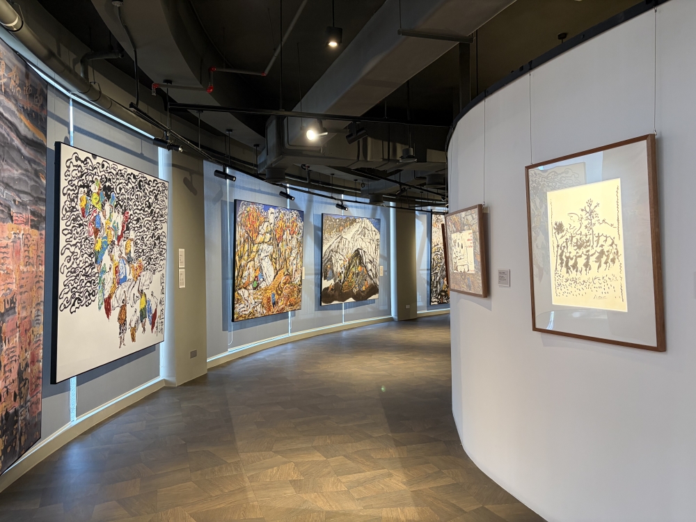 Lin Xiang Xiong’s paintings depicting raw realities of war on the left and prints with messages for peace by Picasso. — Picture by Opalyn Mok