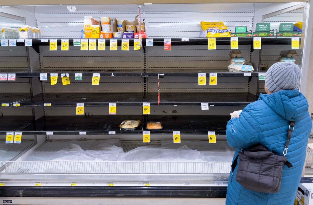 A person shops for eggs on mostly empty shelves as residents stock up on supplies ahead of a cold front expected in the area in Arlington, Virginia, on January 23, 2026. — AFP pic