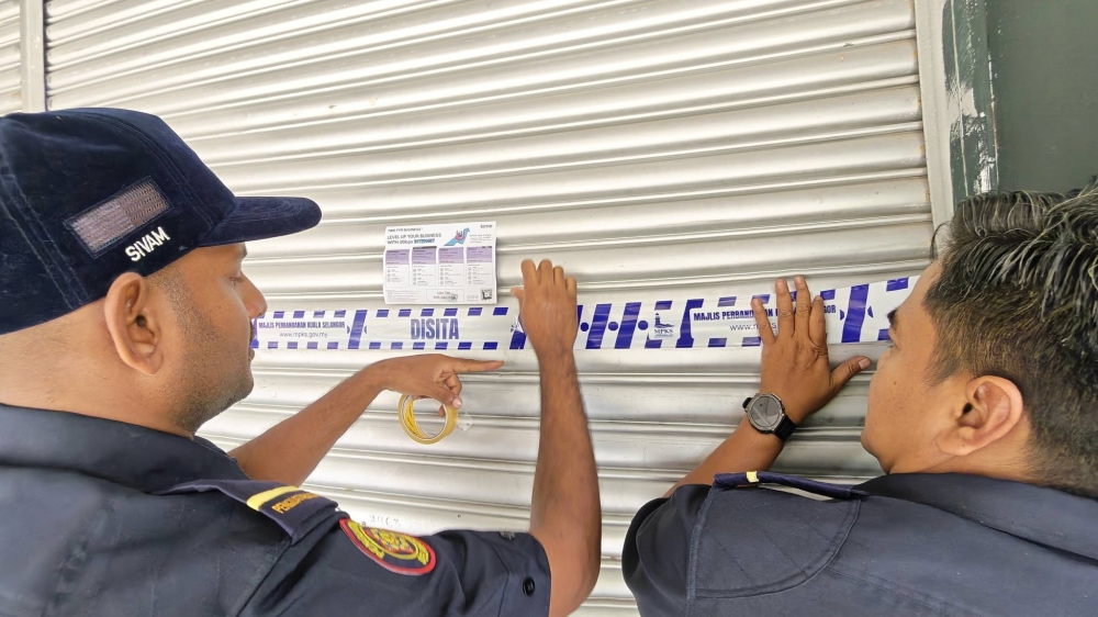 Kuala Selangor Municipal Council (MPKS) enforcement officers seal a premises in Puncak Alam during a joint raid with Immigration and the Companies Commission of Malaysia. — Picture via Facebook/mpksofficial