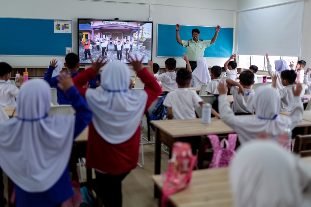 A teacher conducts a learning activity with Year One pupils at a primary school in Johor Bahru on January 21. — Bernama pic