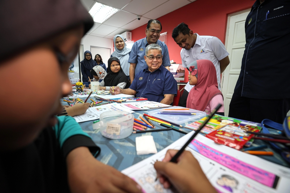 National Unity Minister Datuk Aaron Ago Dagang mingles with children during the 2026 Komuniti Rakyat Madani Satellite Programme at the National Information Dissemination Centre (Nadi) Smart Service Centre in Kampung Dato’ Ahmad Said, Manjoi, January 24, 2026. — Bernama pic