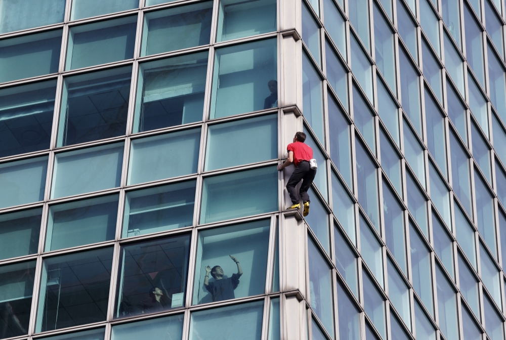 Climber Alex Honnold in action as onlookers inside Taipei 101 film and wave during his free-solo climb in Taipei, Taiwan, on January 25, 2026. — Reuters pic
