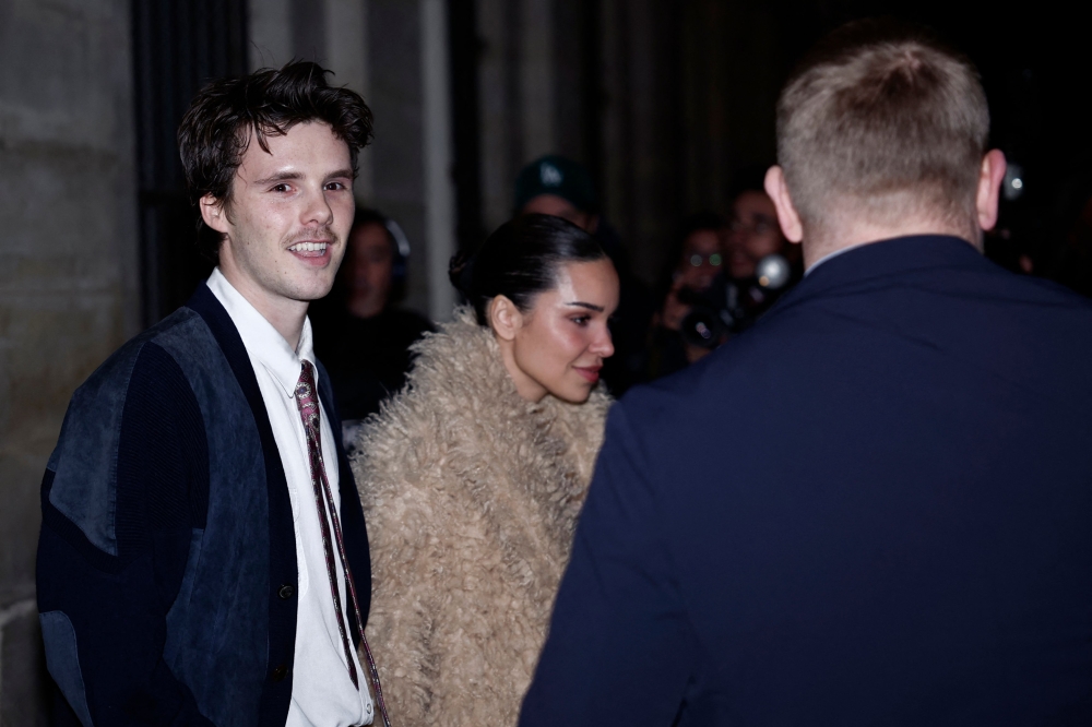 British singer Cruz Beckham (left) and girlfriend Jackie Apostel (centre) leave the Ministry of Culture after a attending a ceremony where her mother, English fashion designer Victoria Beckham, was awarded Knight of the Order of Arts and Letters, in Paris, on January 26, 2026. — AFP pic 