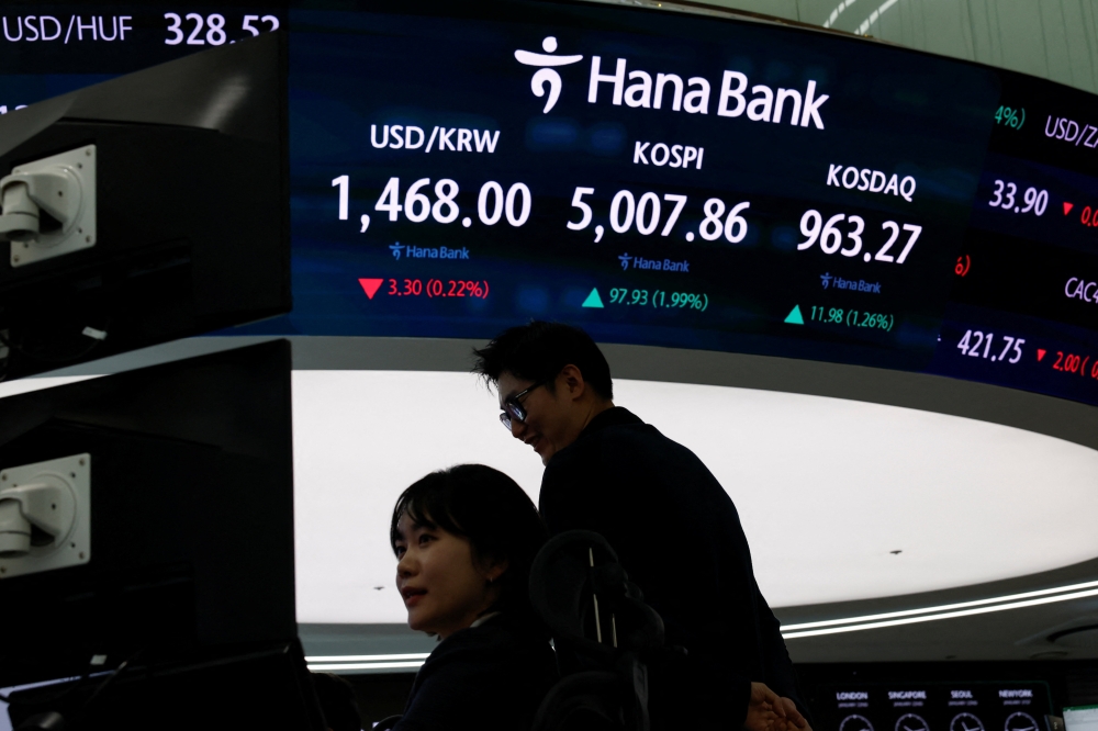 Currency dealers work in front of an electronic board displaying the Korea Composite Stock Price Index (KOSPI) over 5,000 points in the dealing room of a bank, in Seoul January 22, 2026. — Reuters pic