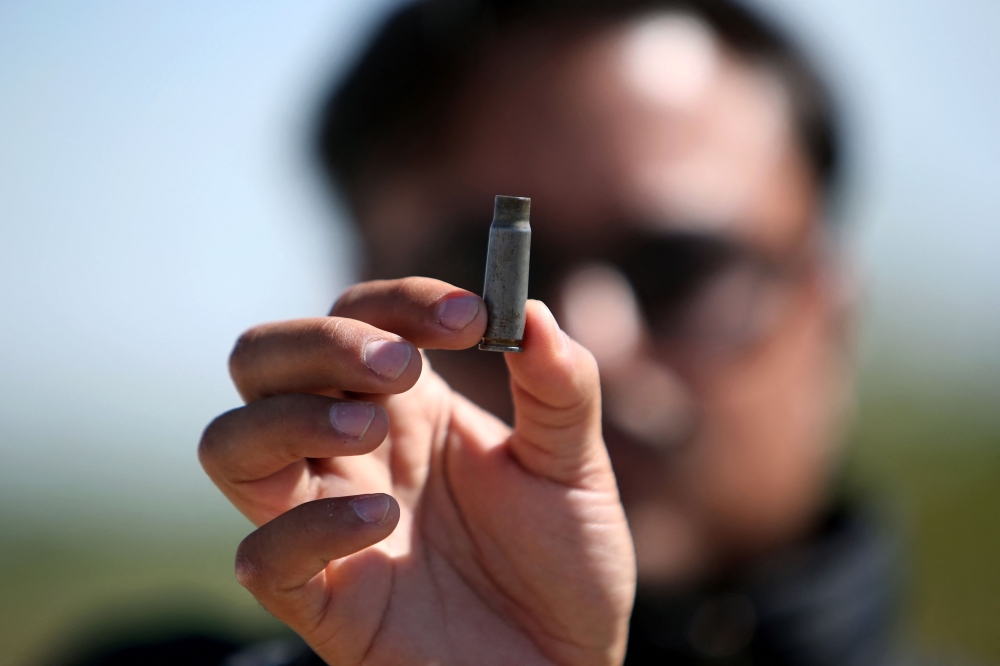 A man holds up a bullet casing found at the Mexican football field in Salamanca, Guanajuato state, on January 26, 2026, where at least 11 people were killed and 12 more wounded during an attack on the eve. — AFP pic