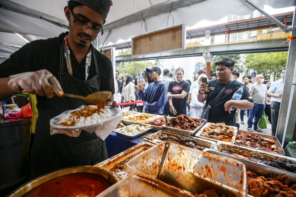 Popular nasi kandar restaurants in Penang such as the legendary Hameediyah, Nasi Kandar Pokok Ketapang and Kapitan Maju are often packed but people are willing to stand in long lines for their turn to tuck in. — Picture by Hari Anggara