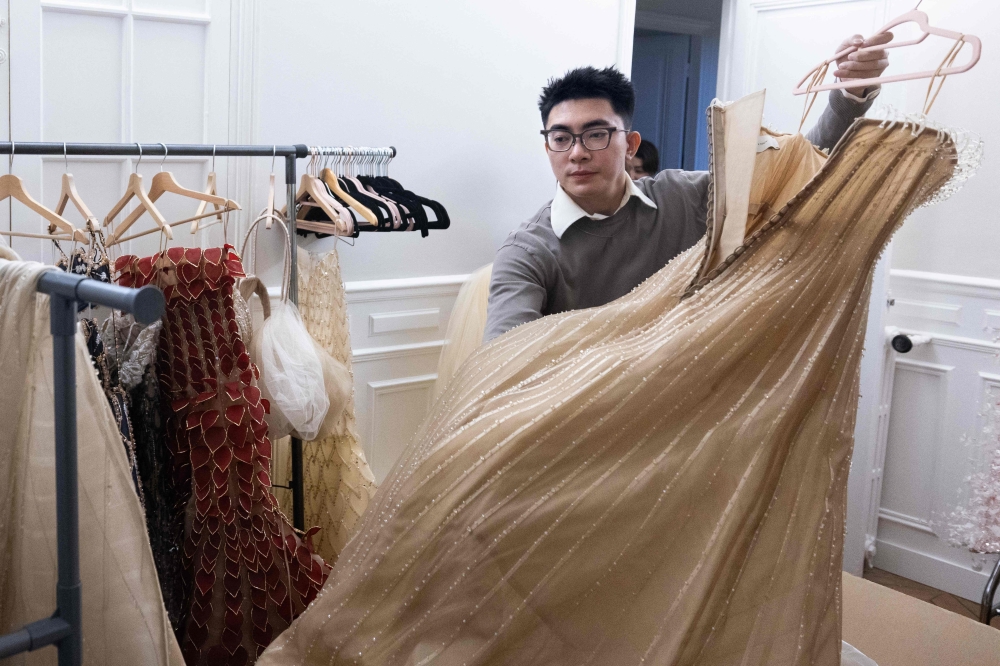 Vietnamese founder and creative director Phan Huy grabs an item of his collection in Paris January 27, 2026. — AFP pic