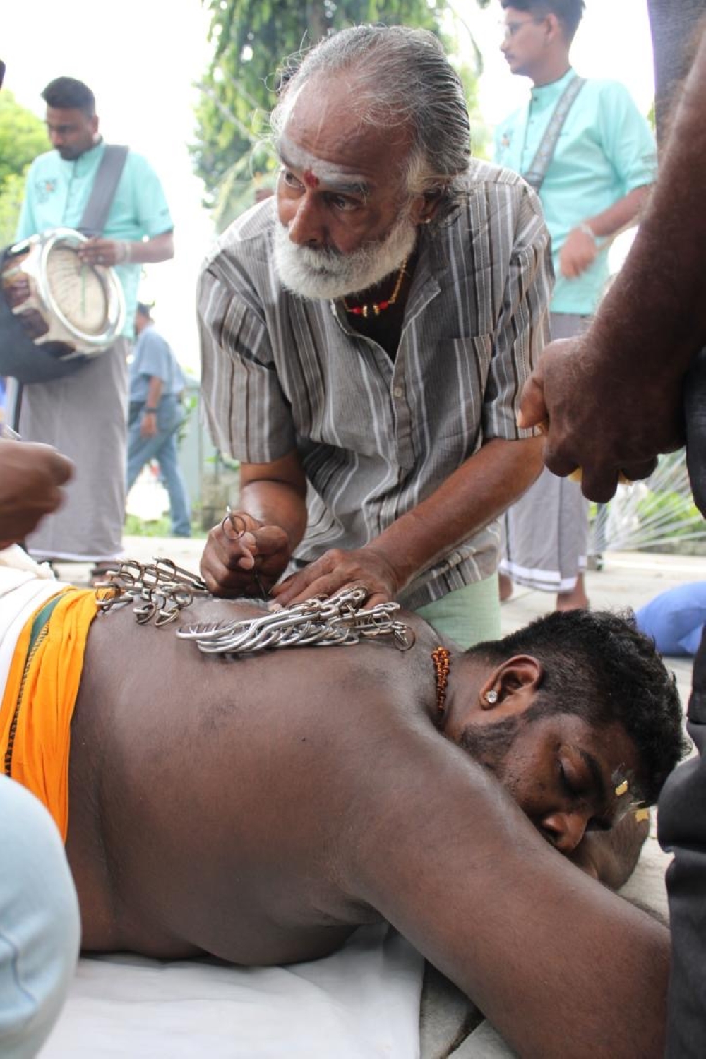 Seasoned ‘kavadi’-maker and body-piercer Asokan Muniandy, 63, attaching metal hooks and skewers on his son, Kuhanraj Asokan, 31, during Thaipusam. — Picture courtesy of Kuhanraj Asokan