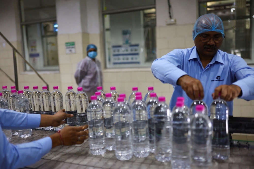 Workers arrange PET (Polyethylene Terephthalate) bottles filled with natural water on a conveyor at Tata’s Himalayan natural mineral water bottling plant in Dhaula Kuan, Himachal Pradesh, October 16, 2025. — Reuters pic