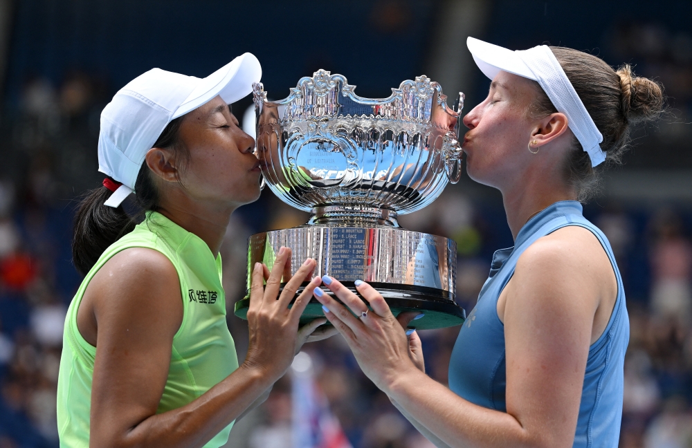 Belgium's Elise Mertens and China's Shuai Zhang kiss the trophy after winning the Australian Open women's doubles final at Melbourne Park, Melbourne January 31, 2026. — Reuters pic
