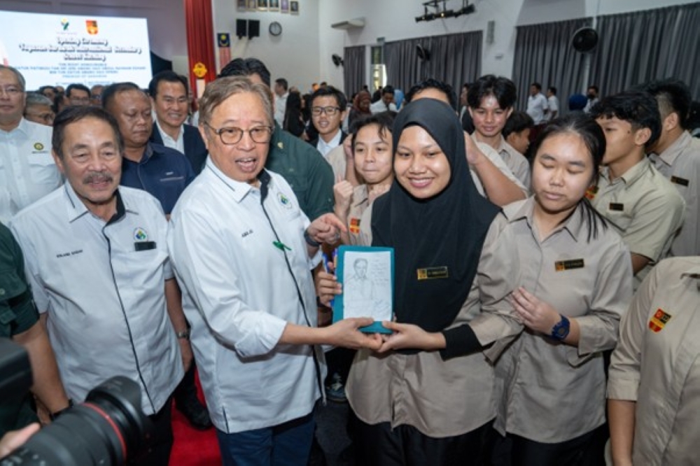 Abang Johari poses for a photo with YSISS students. — The Borneo Post pic