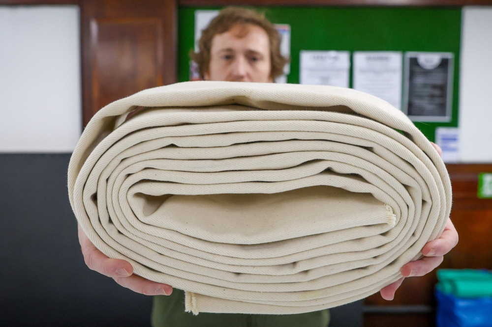 Johnny Templeton, sumo wrestling club founder and coach, holding up a rolled up ‘mawashi’, or belt, that Ireland’s first woman sumo wrestler Toraigh Mallon likened to a ‘wedding dress’ the first time she put it on. — AFP pic