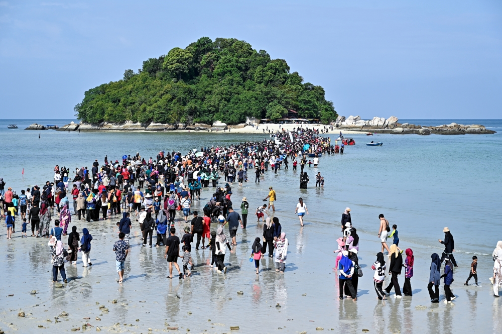Visitors walk on water as Pangkor’s rare ‘split sea’ opens sandy path to Giam Island